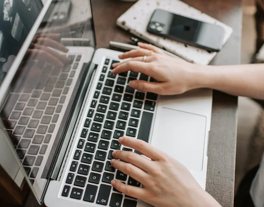 crop female freelancer using laptop at table at home