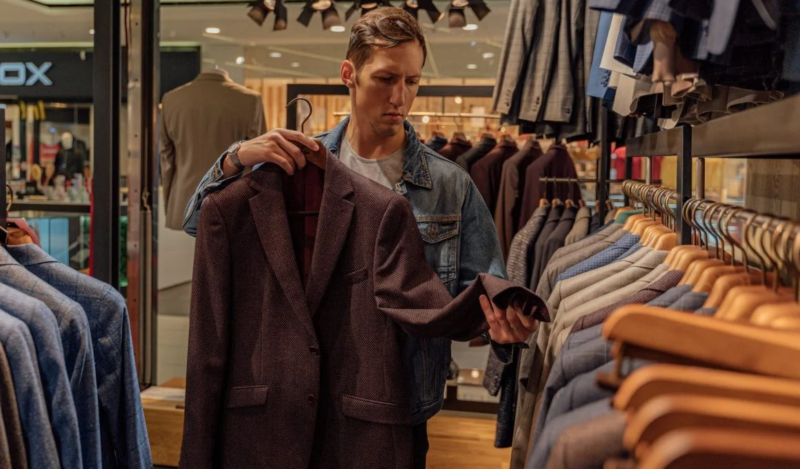 a man looking at a suit jacket in a clothing store