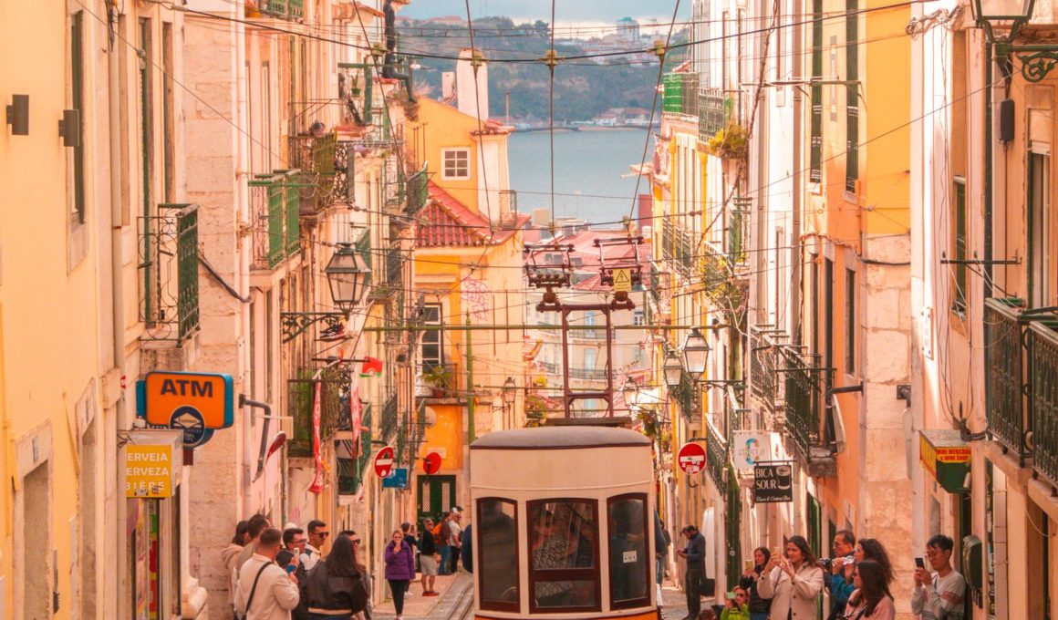 Gele tram tussen kleurrijke gevels in de oude wijk Alfama in Lissabon