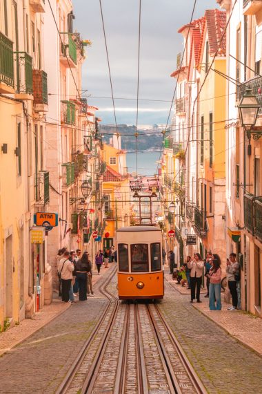 Gele tram tussen kleurrijke gevels in de oude wijk Alfama in Lissabon